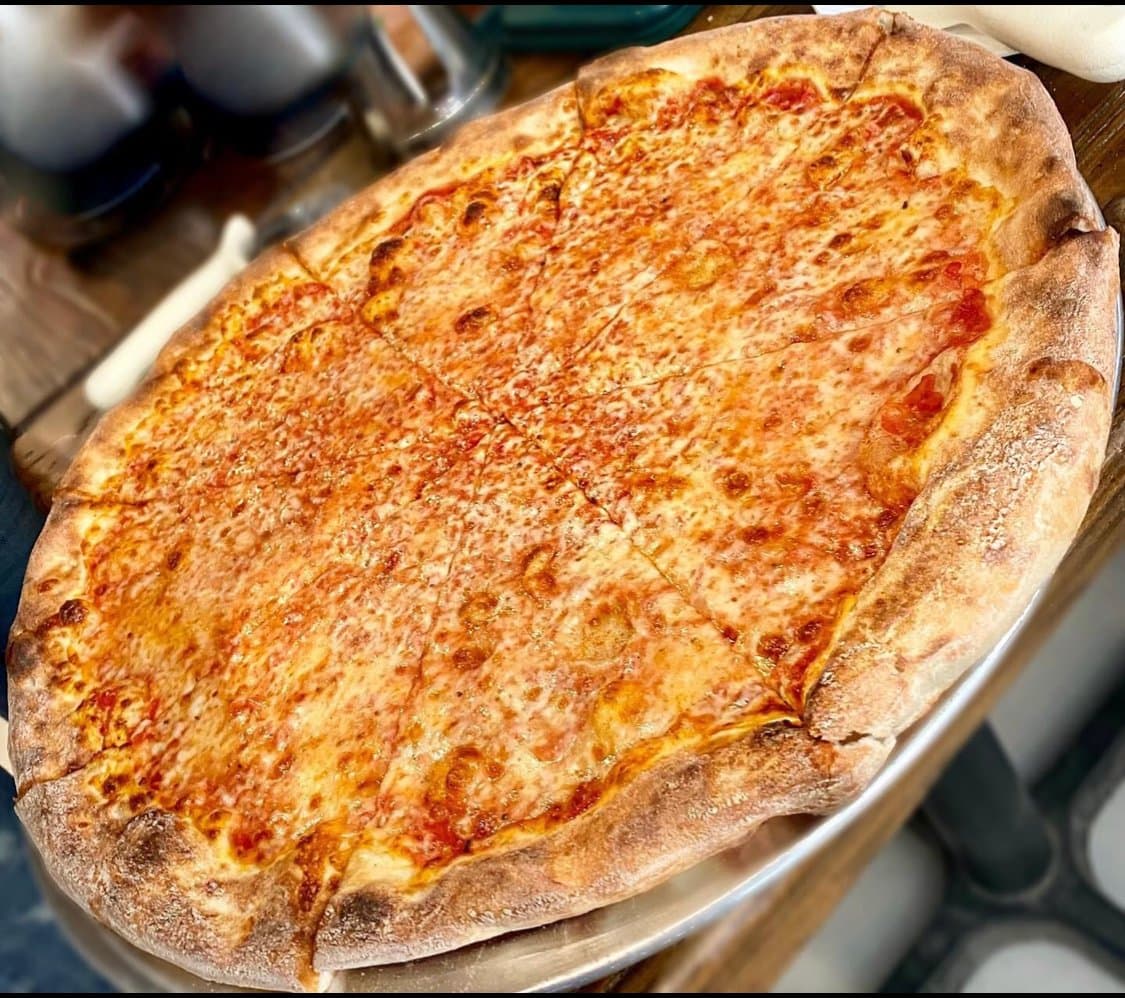 Whole New York style cheese pie fresh from the oven at Austin Street Pizza
